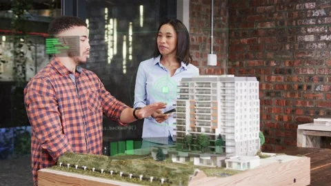 Man presenting and woman tapping device activating AR overlays on model for Stock Footage 332897525