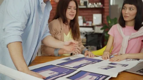 Man presenting app interface templates to female colleagues 動画素材 134785375