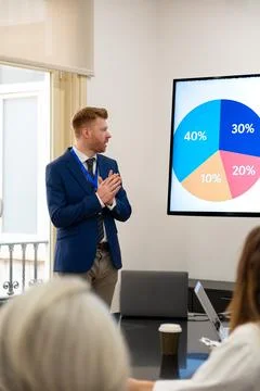 Man presenting business data with a pie chart during meeting Stock Photos