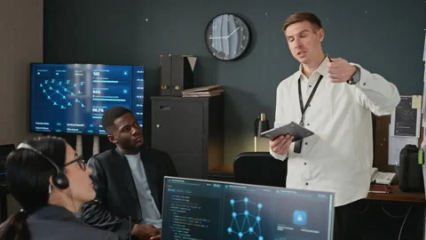 Man Presenting Cybersecurity Data to Multiethnic Team in Office Stock Footage 346816936