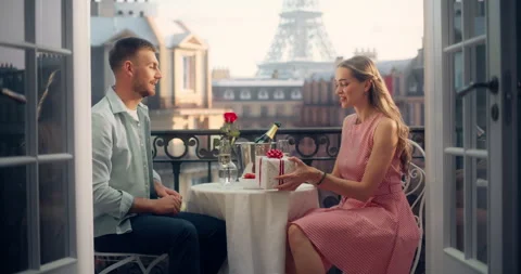 Man Presenting a Gift to Female on Paris Balcony Stock Footage 296172264