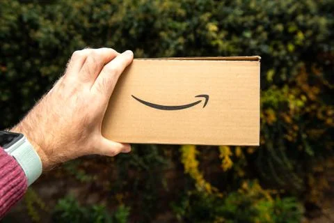 Man presenting new cardboard box Amazon Prime parcel Foto stock