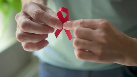Man Presenting Red Ribbon for World AIDS Day Stock Footage 316754038