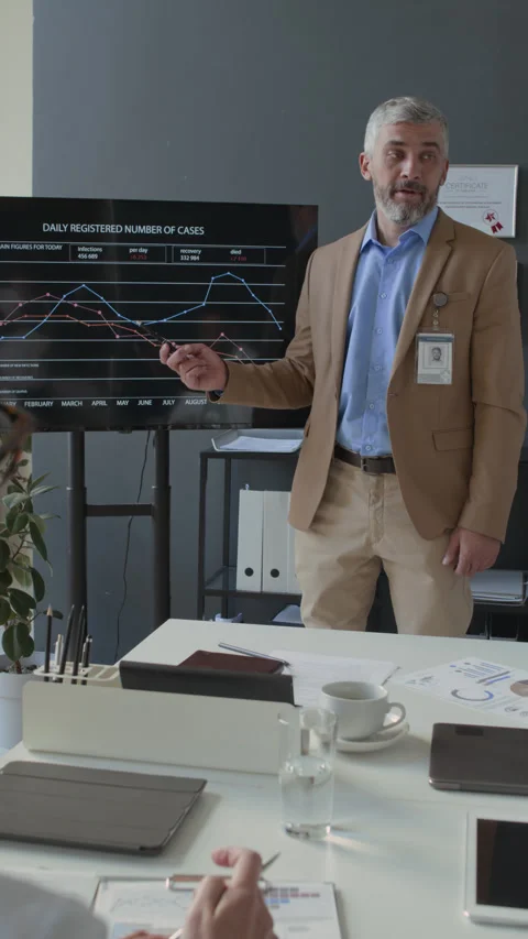 Man Presenting Statistical Data on Screen to Healthcare Professionals at Meeting Stock Footage 295288574