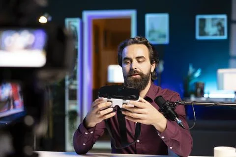 Man presenting VR goggles to audience, filming video with professional camera Stock Photos