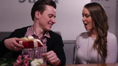 Man presents a gift to a young beautiful woman, she is happy 库存影片 59189765
