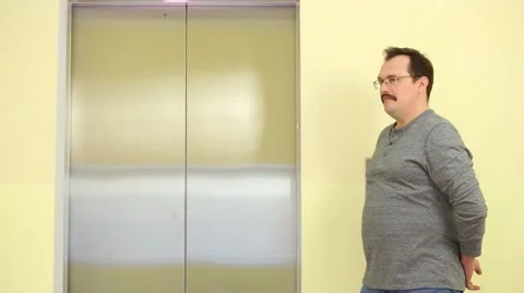 Man presses a button, and standing at the open elevator Video stock 61771237