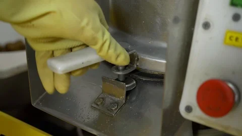 A man presses a button and turns off the machine for cleaning vegetables Stockbeeldmateriaal 89608769