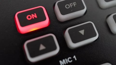 The man presses the button to turn on the microphone. The button lights up in Video stock 233371952