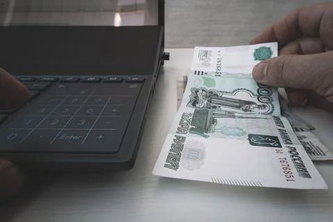 Man presses a calculator button with his finger. man counting ruble. cash acc Stock Photos