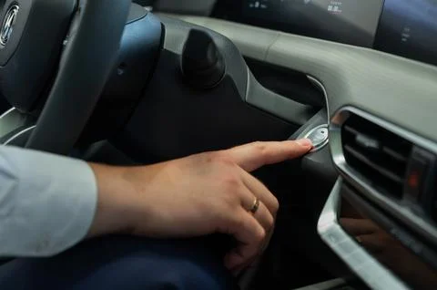 A man presses the car engine start button. Stock Photos