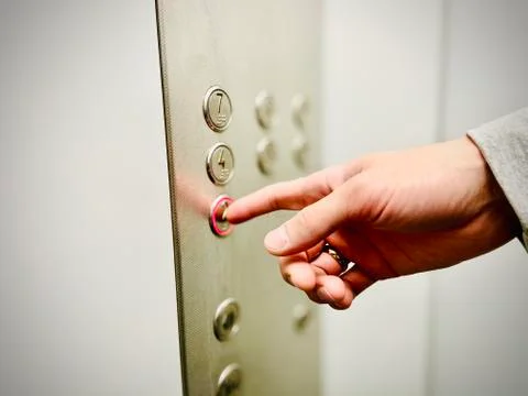 The man presses the elevator button with his hand. A close-up. Mobile photo. Stock Photos