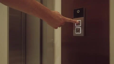 The man presses the elevator call button and goes inside. Close-up Stockbeeldmateriaal 249963240