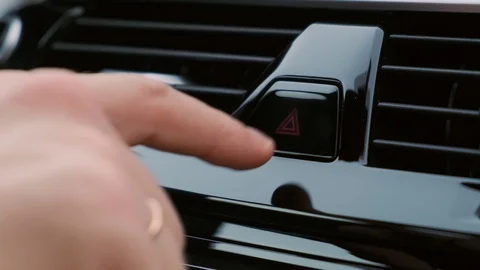 A man presses the emergency button in the car. Button blinks lights flash. Stock Footage 125262330
