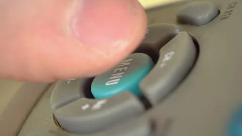 Man presses a menu button on remote Stock-Fotos