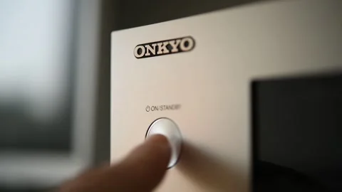 A man presses the power button on an Onkyo Tx - 8250 stereo receiver. Video stock 302540839