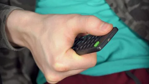 Man presses red button of the TV remote Fotos Stock
