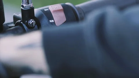 Man presses the start engine button on handlebar motorcycle Stock Footage 115630317