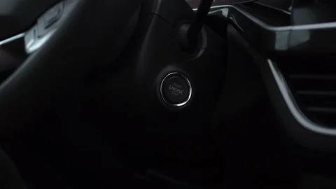 Man presses the start stop button with his finger start a new car after purchase Stock Footage 140962413