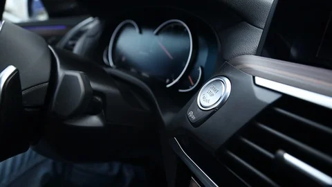 The man presses the "start stop engine" button. Keyless start system of the car  Stock Footage 121529589