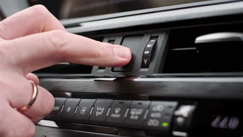 Man presses a warning triangle sign inside car black interior of a luxury car Stock Footage 171801503