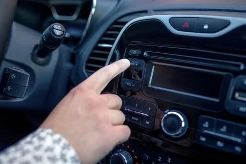A man Pressing Button On Dashboard While Driving Car Foto stock