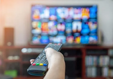 The man pressing button on TV remote control. Foto stock