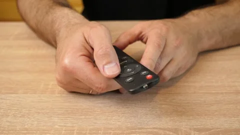 Man pressing buttons on remote control, switching functions Stock Footage 318207524