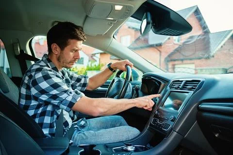 Man pressing car engine start button inside vehicle Stock Photos