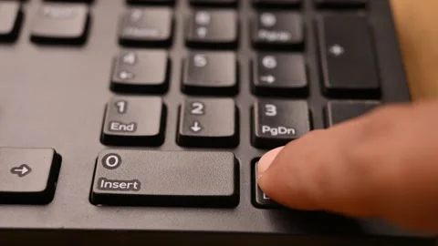 Man Pressing Delete Key on Keyboard to Remove Selected Content on Computer Stock Footage 333579085