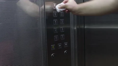 Man is pressing elevator's floor button with tissue or paper towel inside Video stock 140978424