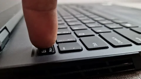 Man pressing escape button on laptop computer keyboard, finger pushing esc key Stock Footage 227759294
