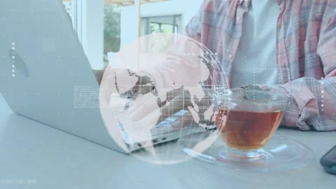 Man pressing laptop keys and activating globe overlay while manipulating data Stock Footage 335282957