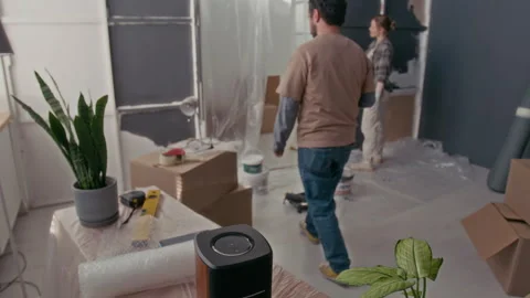 Man Pressing Power Button of Portable Stereo Speaker and Painting Wall Stock Footage 302762975