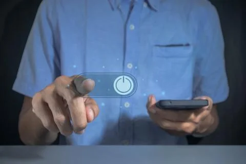 Man pressing power button on virtual screen to turn on or off a smartphone Stock Photos