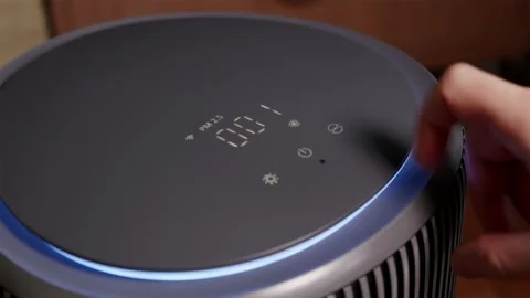 Man pressing touch panel on smart air purifier display Stock Footage 343872626