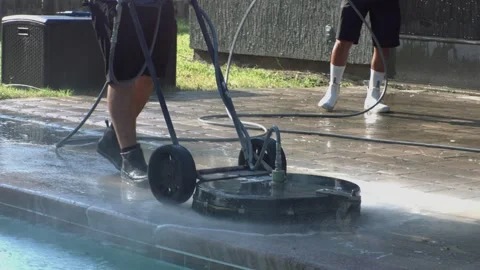 A man pressure washing by a pool Stock Footage 328385958