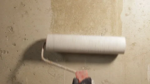 A man primers a concrete wall with a roller Stock Footage 88474301