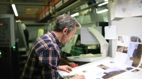Man in printing house controling sample before edition Stock Footage 59775559
