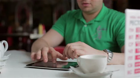 Man prints on the Tablet sitting in Cafe Stock Footage 48908848
