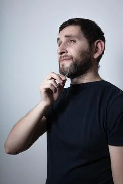 Man with the problem of graying beard Plucking Hair with Tweezers from his beard Stock Photos