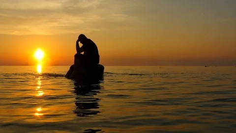 Man with problems isolated thinking on a rock in the open sea Stock Footage 93174008