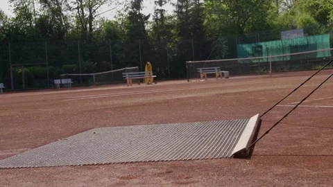 Man in the process of cleaning the clay tennis court, view to legs and brushes Video stock 279345725