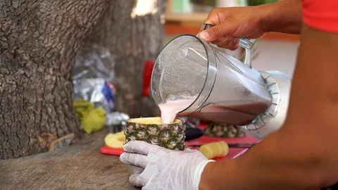 Man in Process of Preparing Pineapple Milkshake with Blender in Beach Bar. Stockbeeldmateriaal 129185490