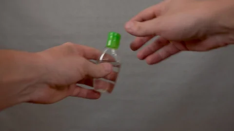 Man processes his hands with a sanitizer, pours from a can on his hand and rubs 库存影片 128137862