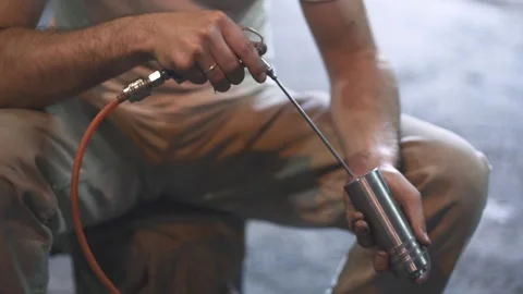 A man processes a metal product with a tool Stock Footage 288485355
