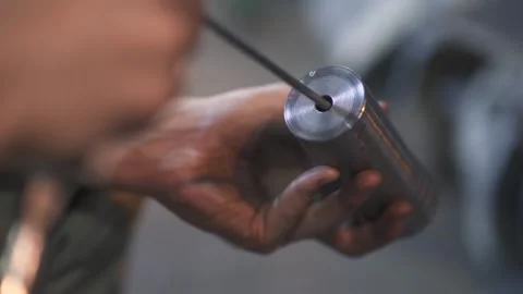 A man processes a metal product with a tool Stock Footage 288485394