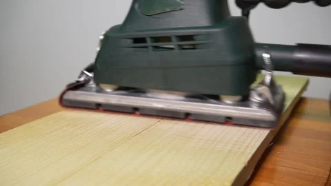 A man processes a wooden board with a sander in a Woodworking Workshop. Close Up Stock-Footage 329069542