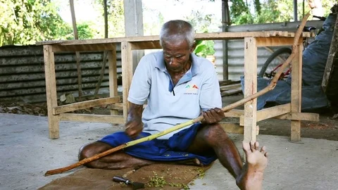 Man is processing branches of cinnamon in small workshop in traditional style Stock Footage 83617414