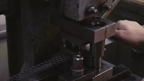 A man in a production workshop works on a machine tool. Produces iron parts. Stock Footage 116011612